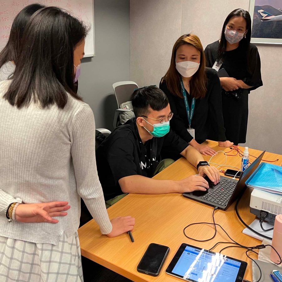 Cathay Pacific team member reviewing travel documents at a Fly Ready station, ensuring compliance with health regulations
