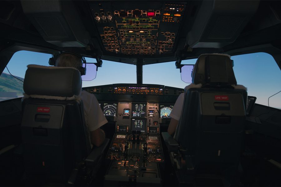 Interior view of a cockpit, where two pilots are at work.