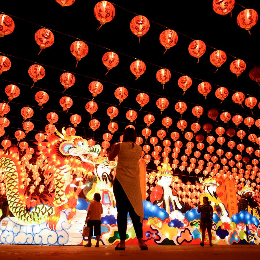 People take photos of red lanterns and an illuminated dragon during the Moon Praying Festival in Thailand. 