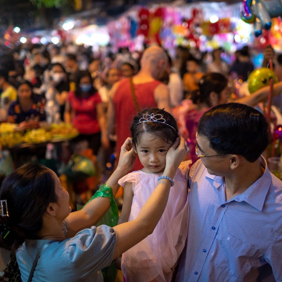 A woman puts a small tiara on a little girl’s head during Tet Trung Thu in Vietnam.