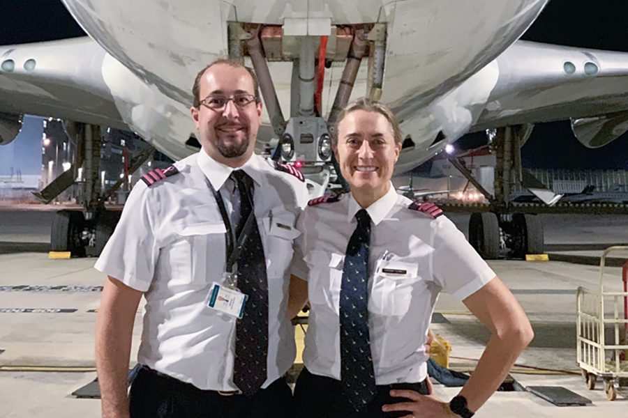Senior First Officer Ignatius Ferreira and Captain Jolene Verwey wear their Fly Pink epaulettes while posing in front of an aircraft.