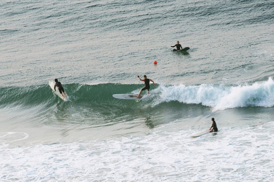 A group of surfers riding a wave at Busan’s Songjeong Beach.