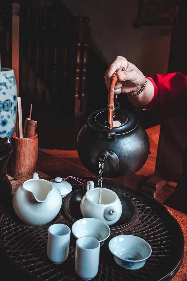 Close-up of a hand pouring water into a teapot at Tea Chapter in Singapore.