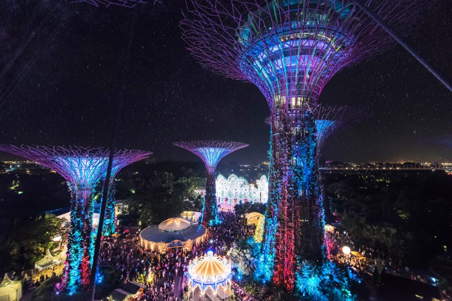 View of the Christmas Wonderland fair in Singapore underneath the illuminated Gardens by the Bay sculptures.
