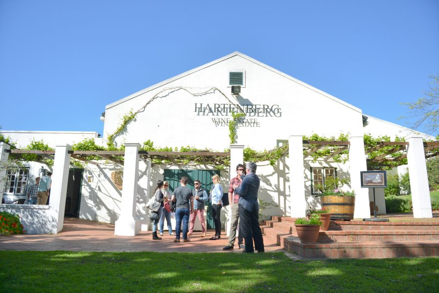 An exterior view of Hartenberg Estate on a sunny day as people chat at the entrance.