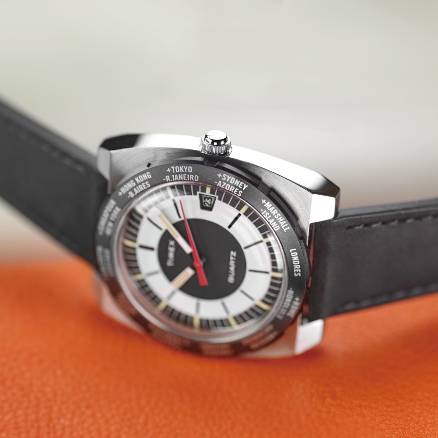 The Timex World Time Reissue 39mm Leather Strap Watch on an orange leather surface.