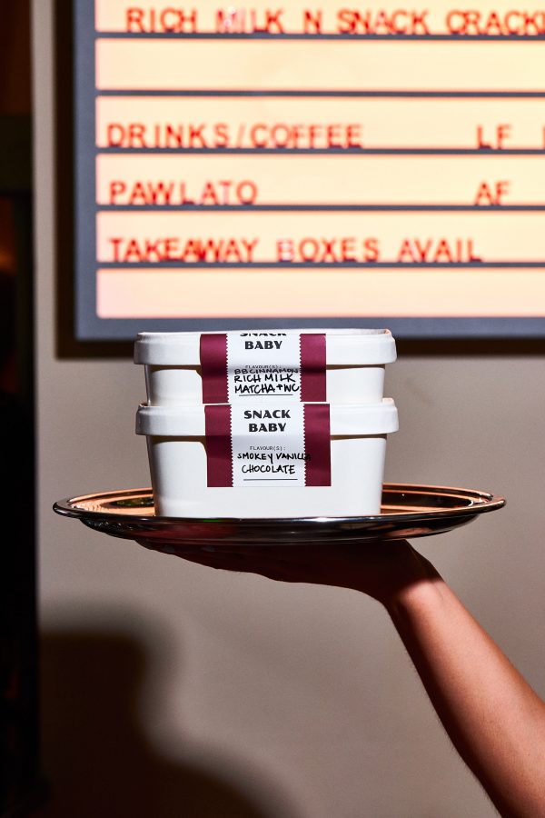 A person holds up a pint of gelato from Snack Baby.