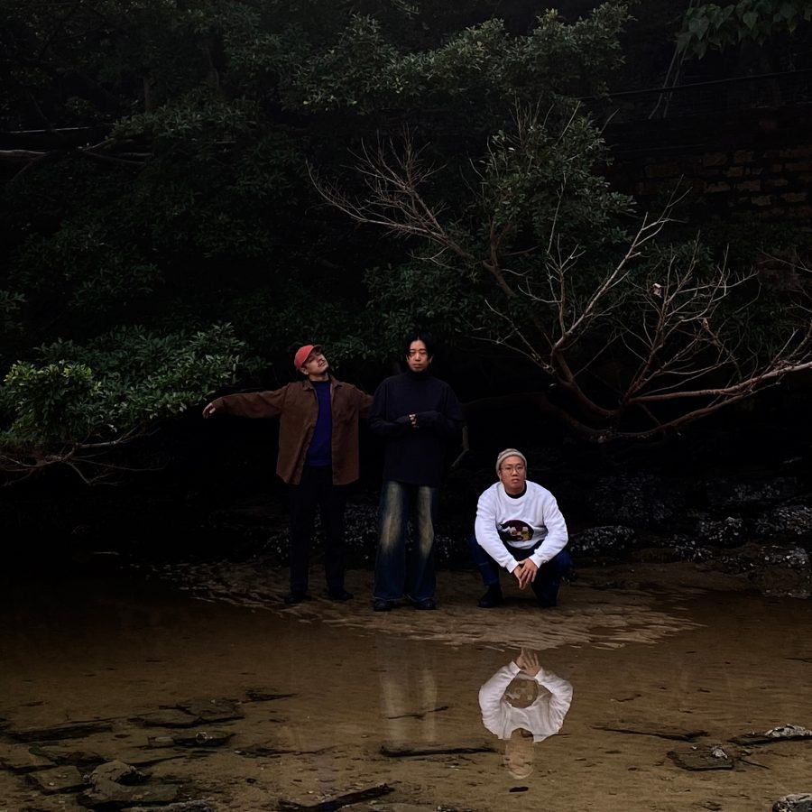Hong Kong musicians Restless Waters pose at the edge of a forested pool of water in Hong Kong.