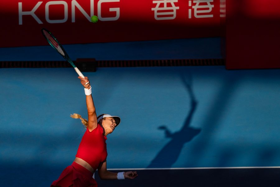 A woman dressed in red, playing tennis.  