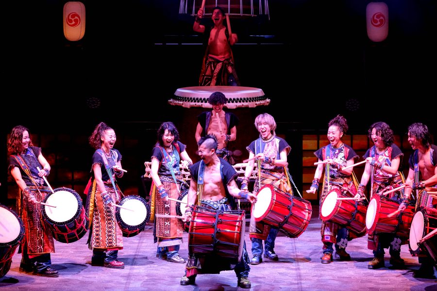 A group of people playing taiko drums during a performance