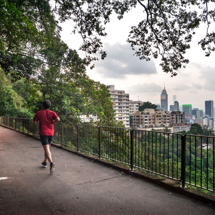 A section of the Bowen Road trail with views of Hong Kong’s skyscrapers and a person running.