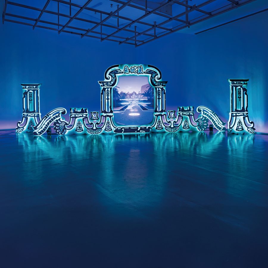 A glowing exhibition of Lawrence Lek's Nepenthe (Summer Palace Ruins) (2022) on display in a blue room