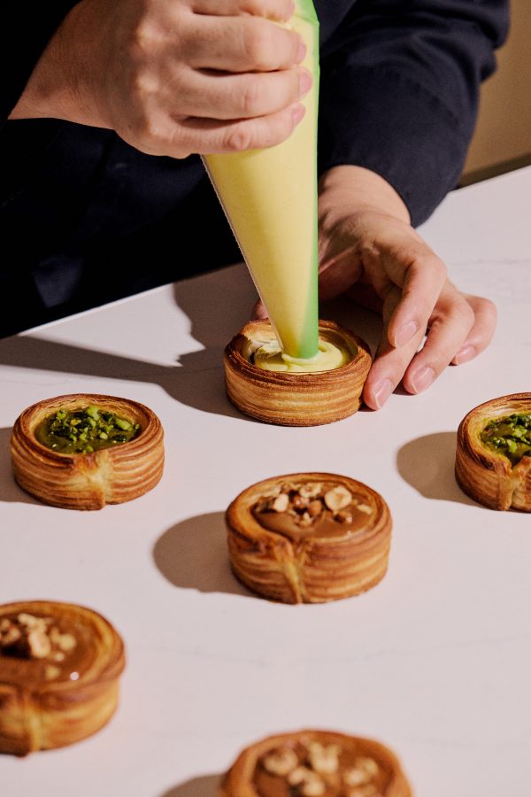 A pastry chef applies the finishing touches to a delicate creation.