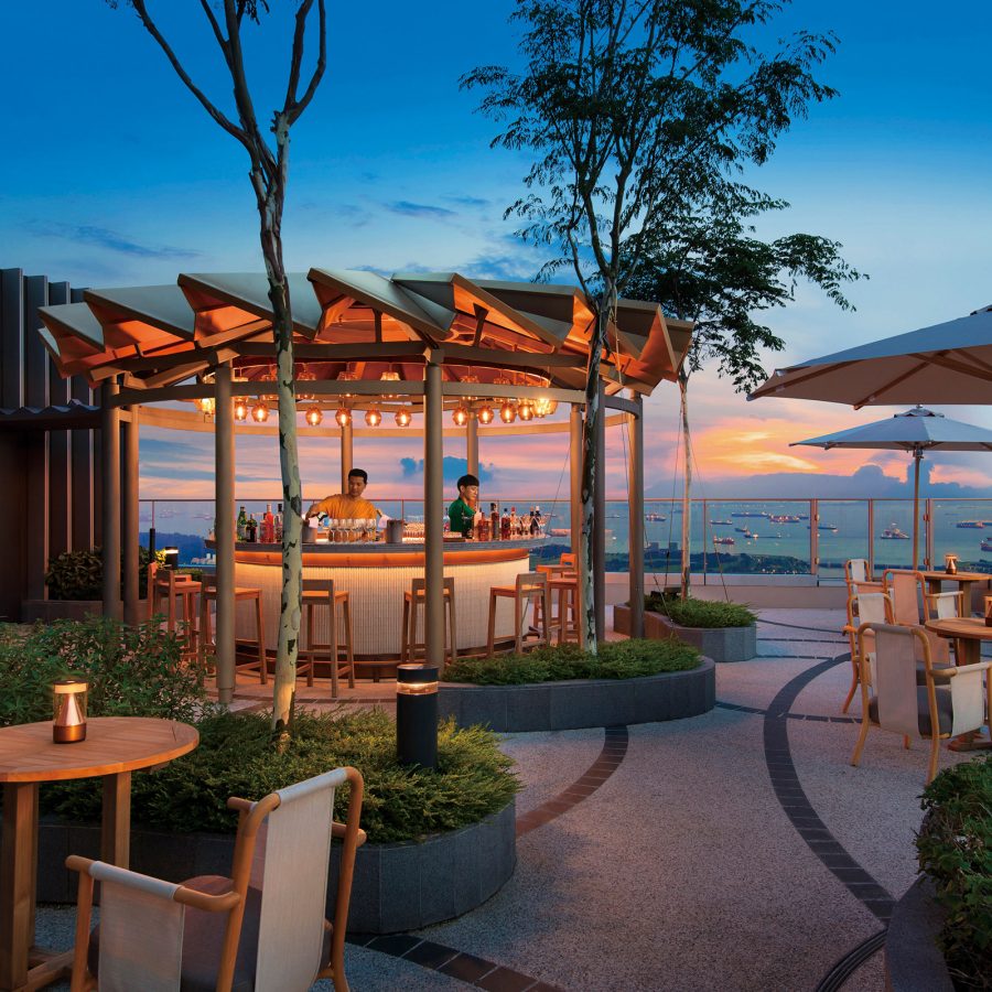 A view of the outdoor bar at Andaz Singapore by Hyatt with a view of the sunset in the background
