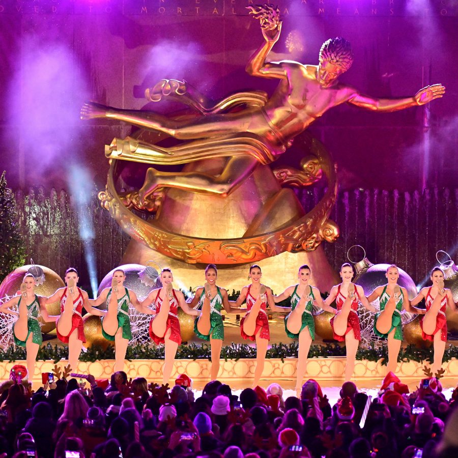 Holiday performance in front of the golden Prometheus statue at Rockefeller Center, with dancers in festive costumes and colourful lights.
