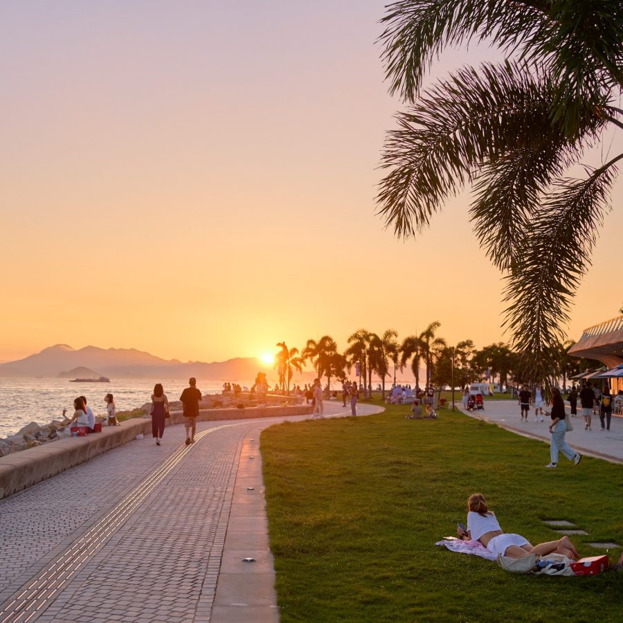 WestK Harbourside Lawn during Sunset, with people walking and playing on the grass.