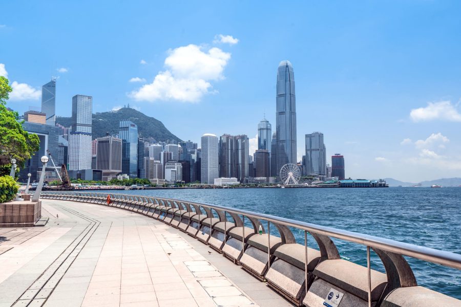 The Hong Kong island skyline from the Wan Chai expo promenade under blue skies along the harbour.