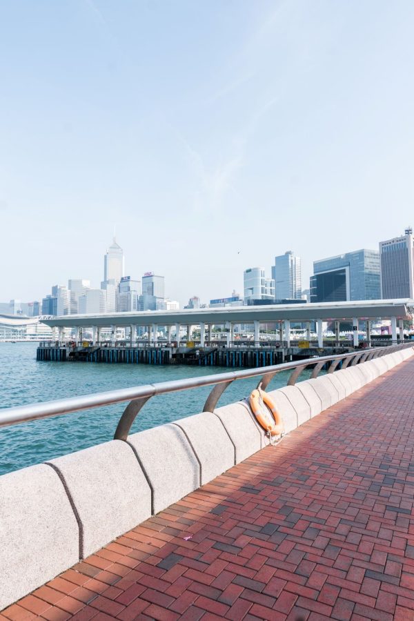 A red bricked paved road on the Central harbourfront with a view of the pier. 