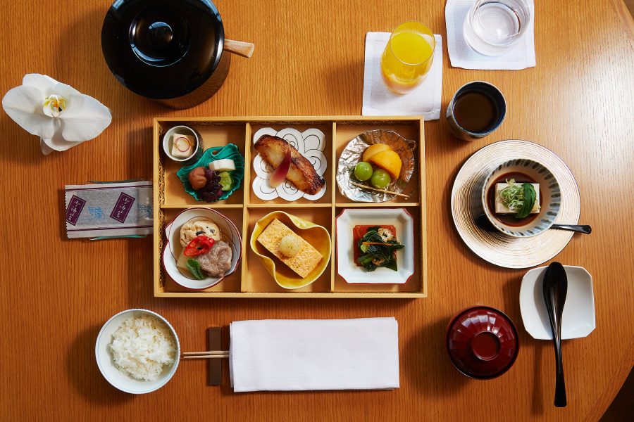 A top-down view of a bento box meal on a wooden table at The Ritz-Carlton, Kyoto.