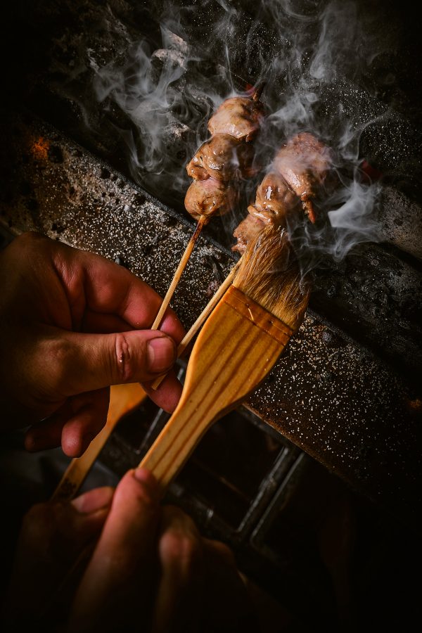 A chef grilling meat skewers at Torikaze.