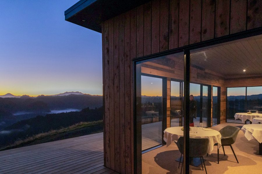A restaurant overlooking a mountain and lake vista.