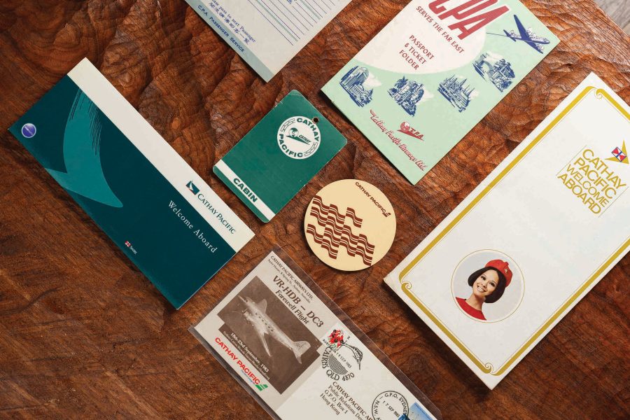 Collection of Cathay Pacific memorabilia arranged on a wooden tabletop.