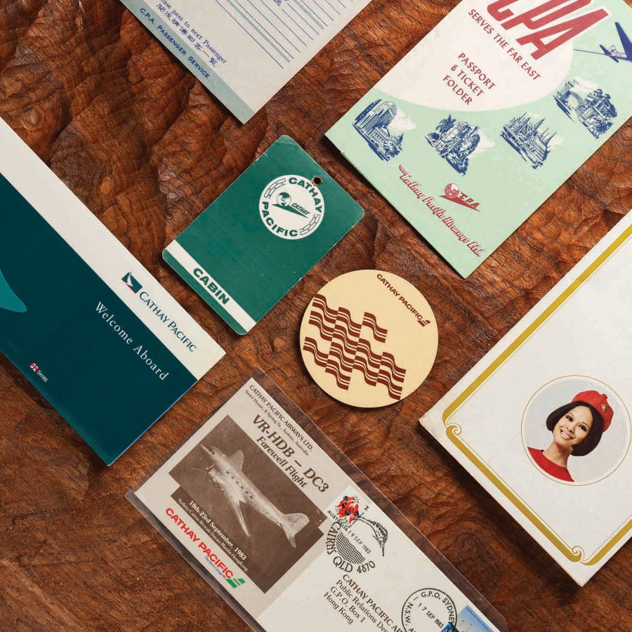 Collection of Cathay Pacific memorabilia arranged on a wooden tabletop.