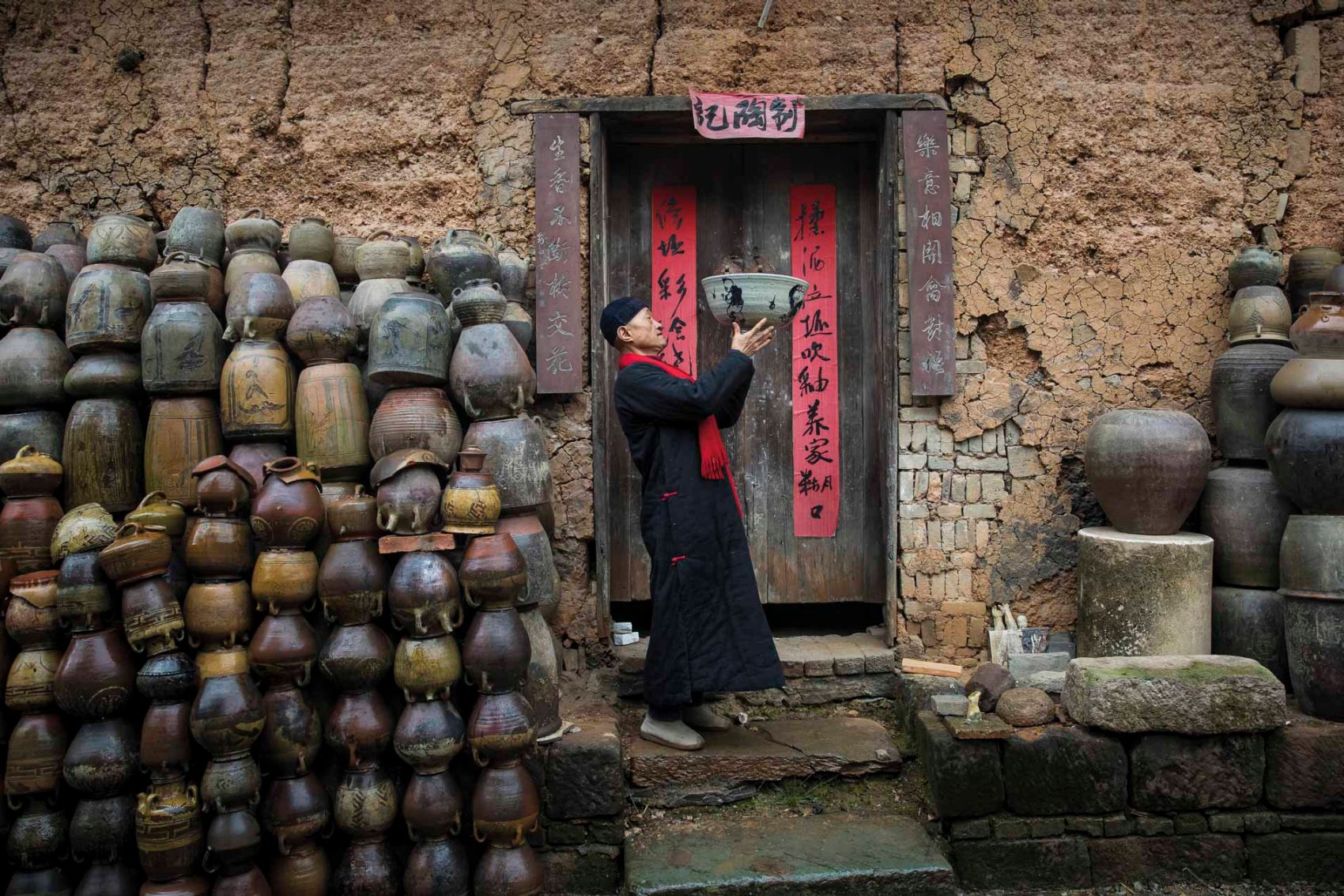 Man in front of porcelain pots. Credit: Qilai Shen