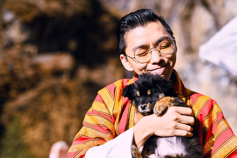 A man is holding a dog in Bhutan.