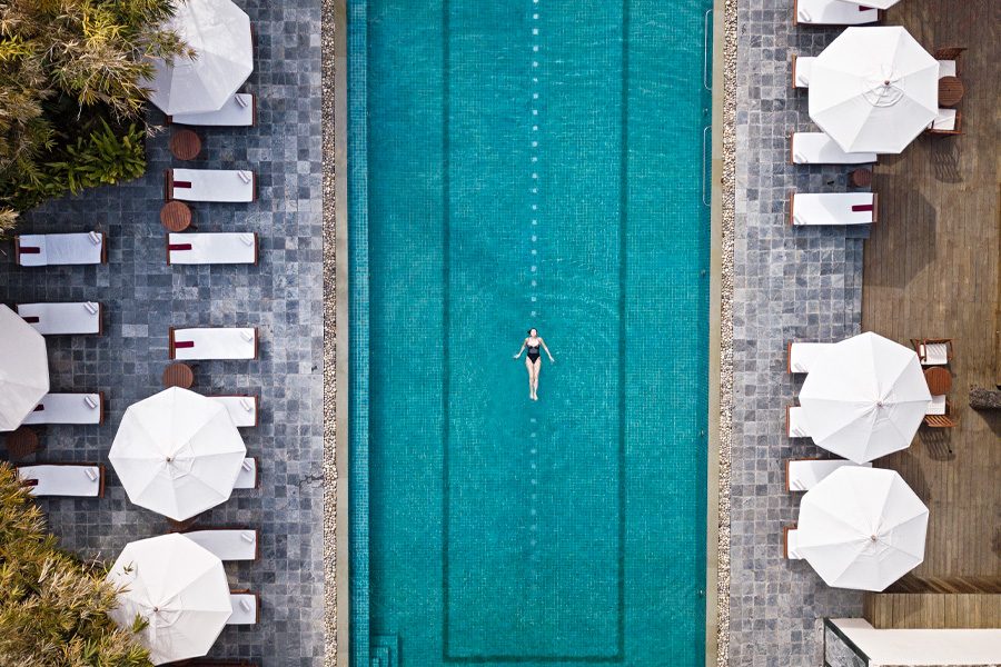 A top view of a woman relaxing in the swimming pool during the day at Ananda in the Himalayas in Rishikesh, India