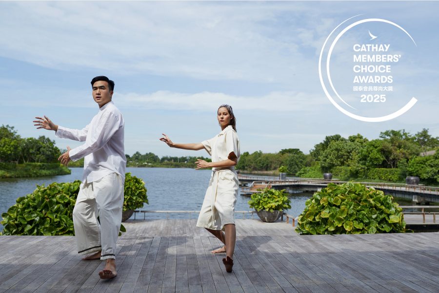 A man and a woman doing tai chi by a lake.