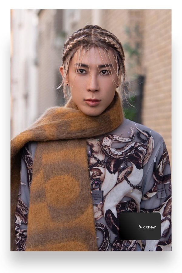 Fashion expert Mayao Ma poses wearing a large brown scarf and patterned top.