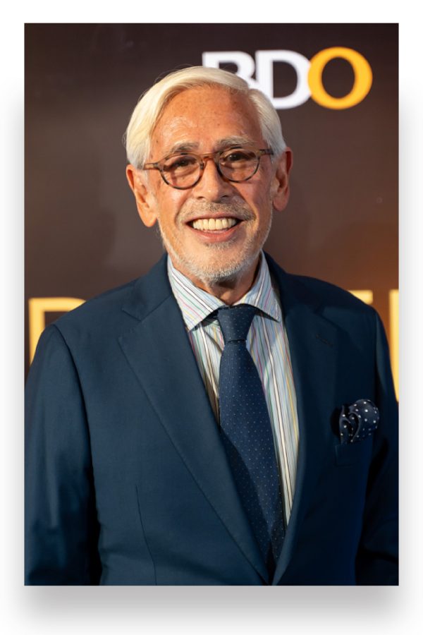 Metro Society Editor-in-Chief Raul Manzano smiles against a step and repeat board.
