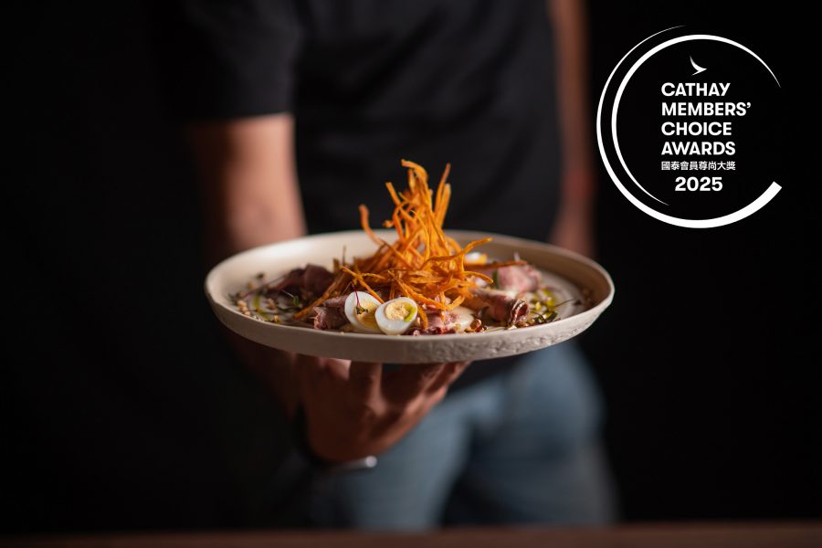 A close-up of a person holding up a dish served at Maido in Lima, Peru.