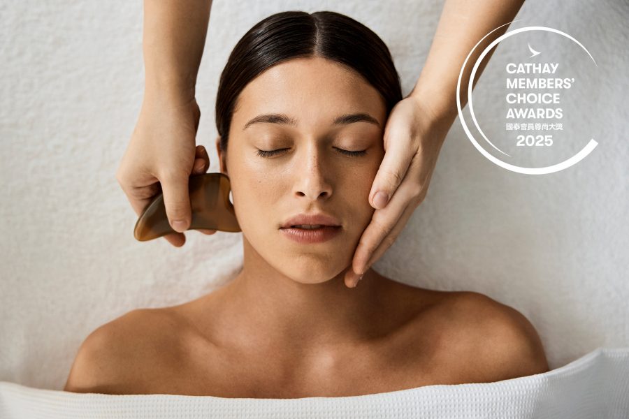 A woman receiving a face massage with guasha. 