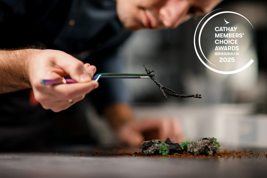 A chef placing a garnish onto a dish.