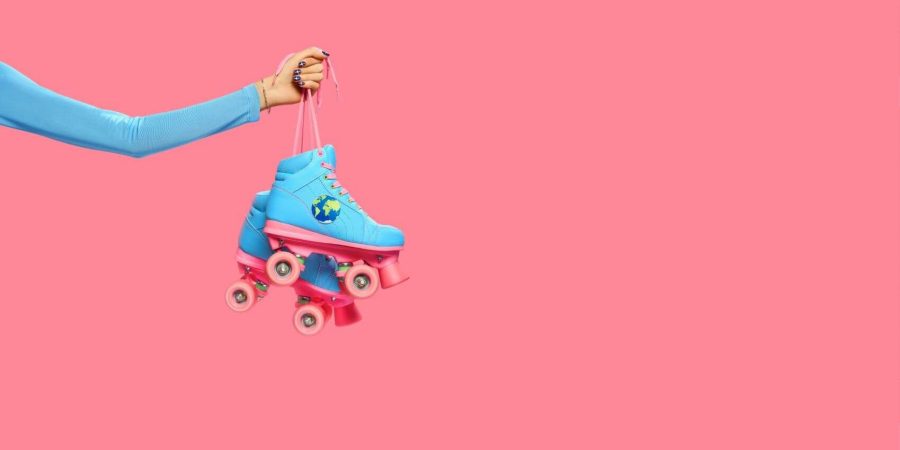 a hand holding a pair of rollerskates in blue