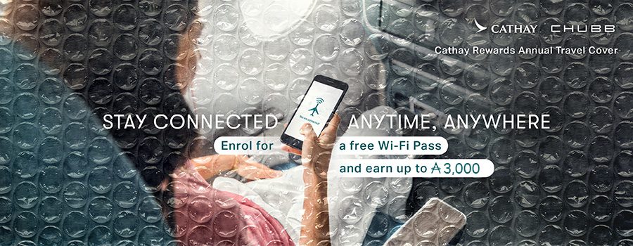 A woman holding her phone enjoying inflight Wi-Fi. Stay connected, anytime, anywhere. Enrol in Cathay Rewards Annual Travel Cover for a free Wi-Fi pass and earn up to 4,000 Asia Miles.