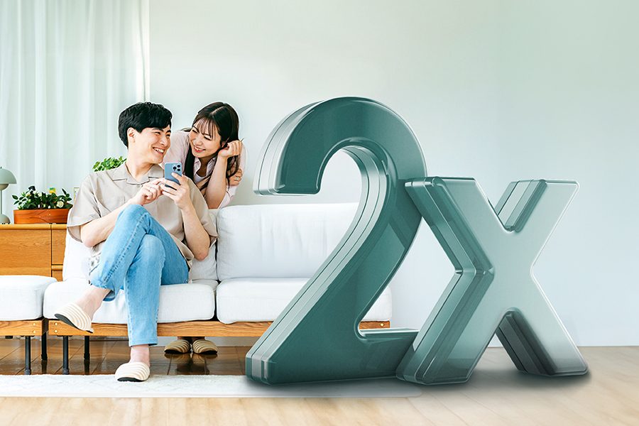 一對情侶坐在沙發上微笑地看著手機，背景中有大型「2X」文字。