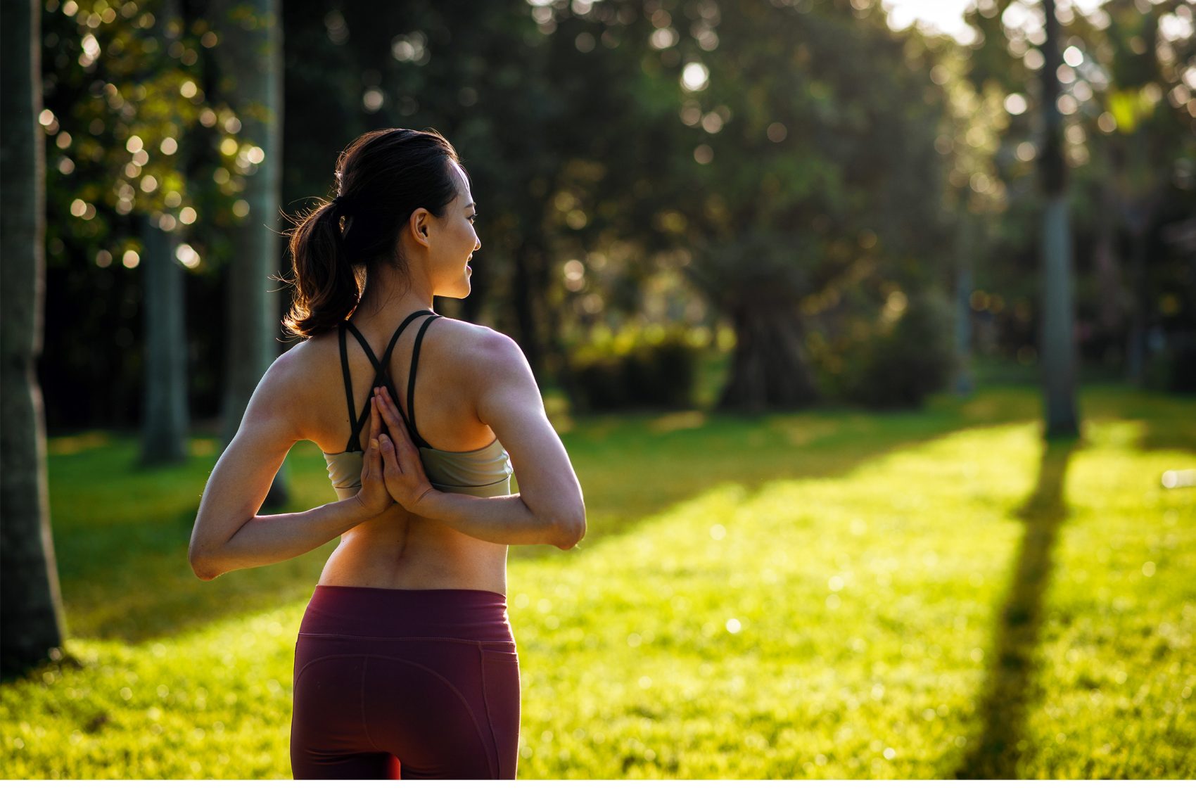 Woman in reverse prayer pose in a field