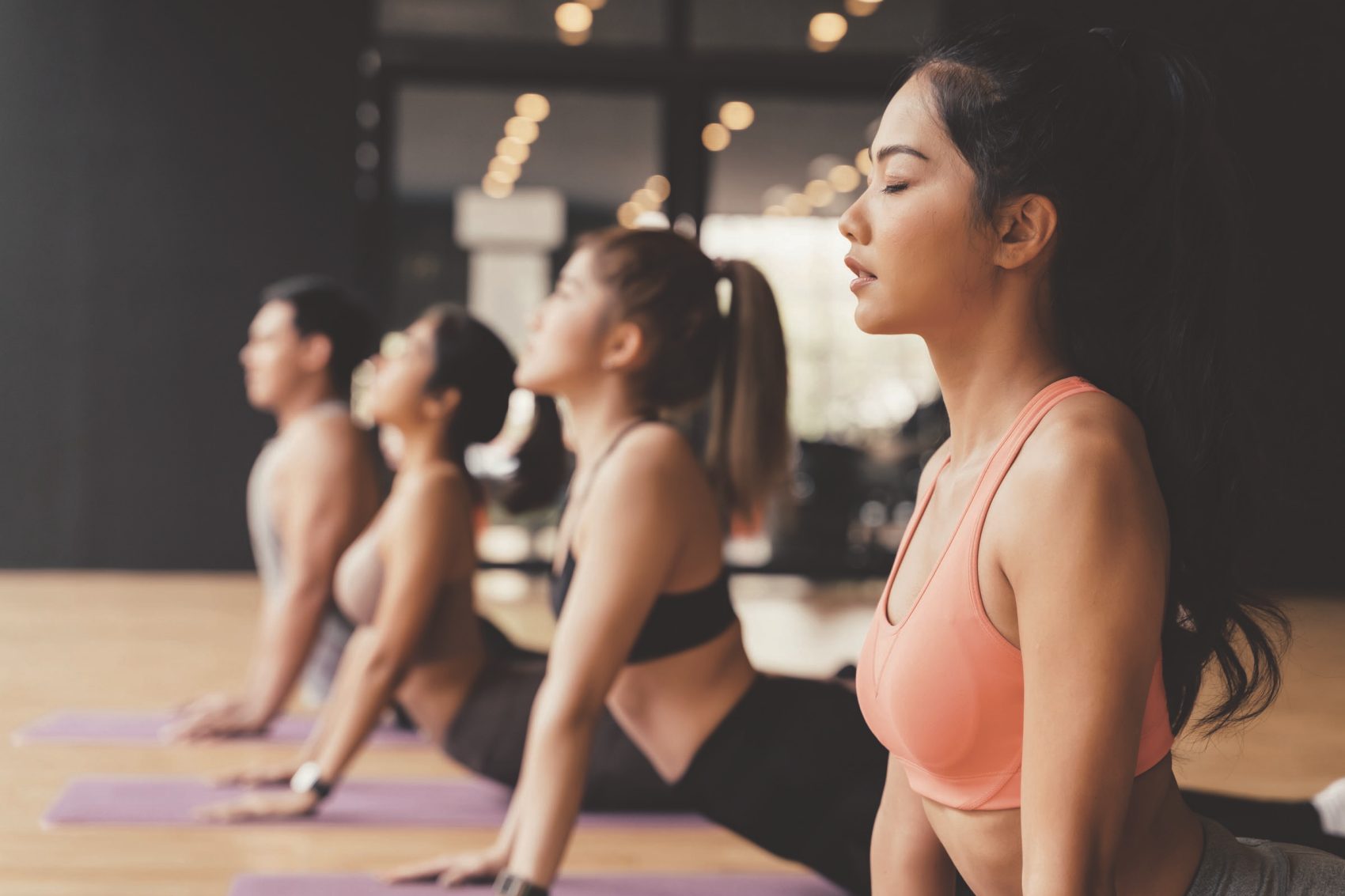 Row of ladies in cobra pose in a yoga class