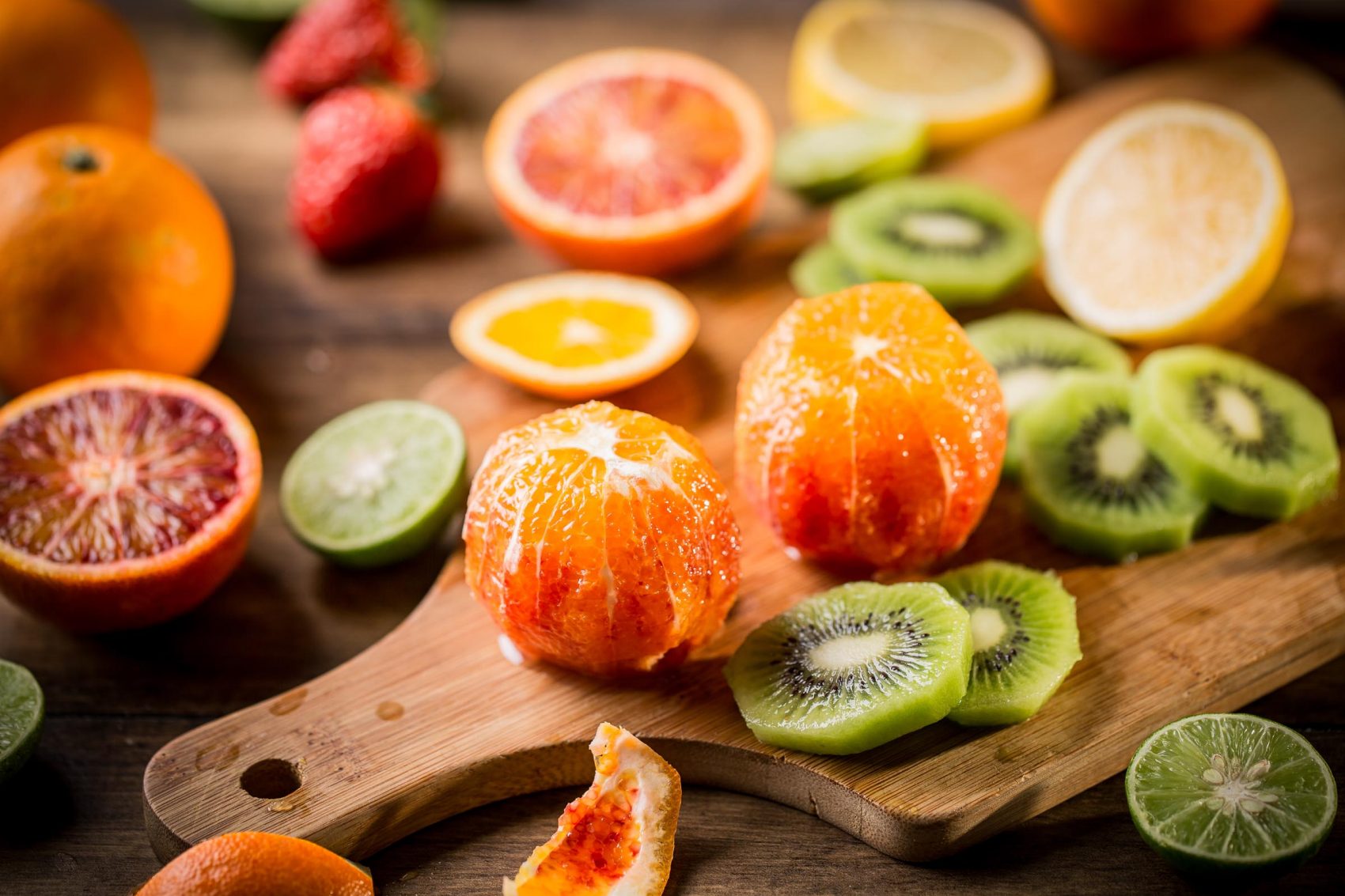Orange, kiwi, lemon and grapefruit on a chopping board
