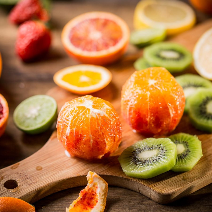Orange, kiwi, lemon and grapefruit on a chopping board