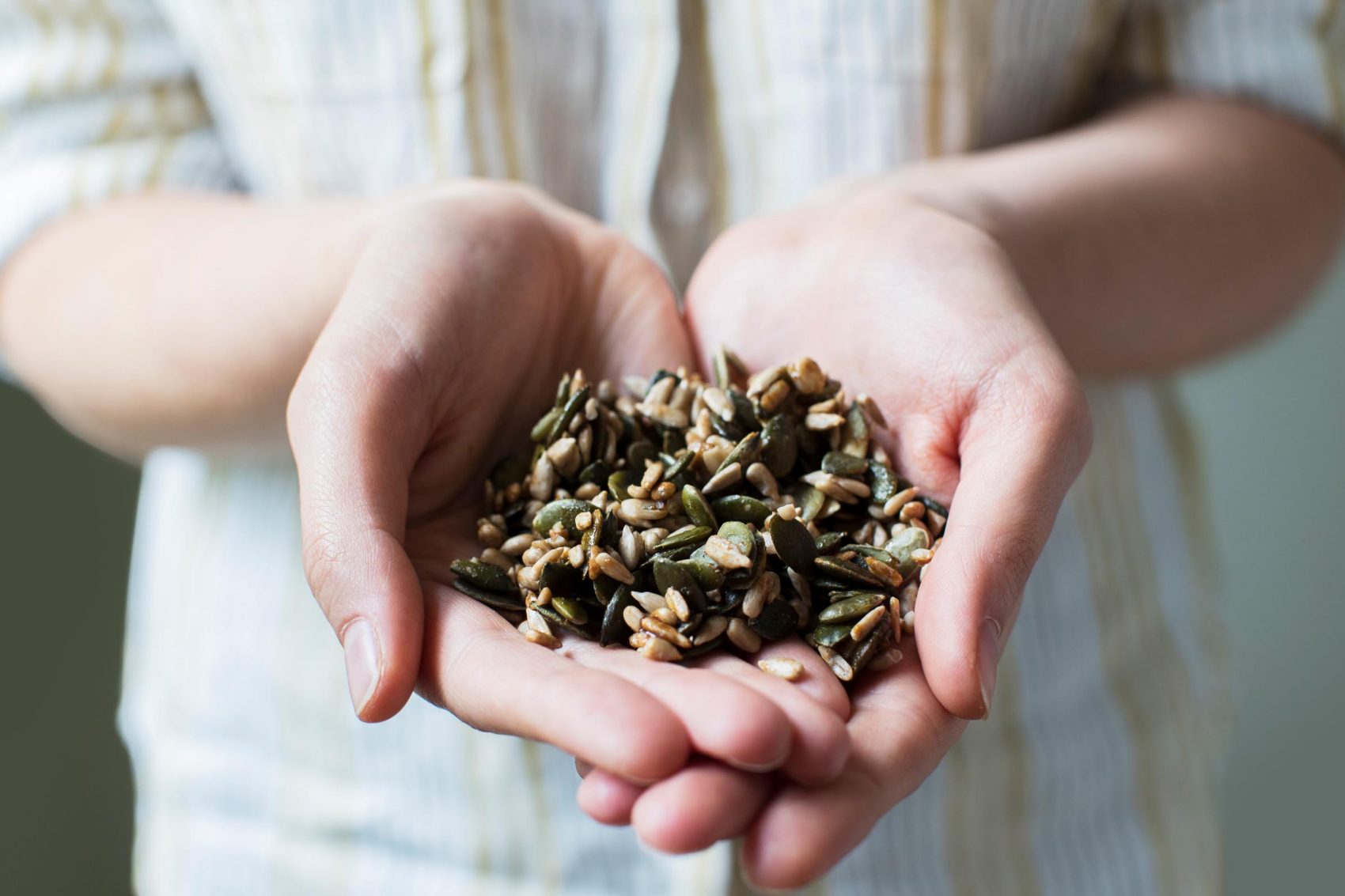 Person holding seeds in the palms of their hands