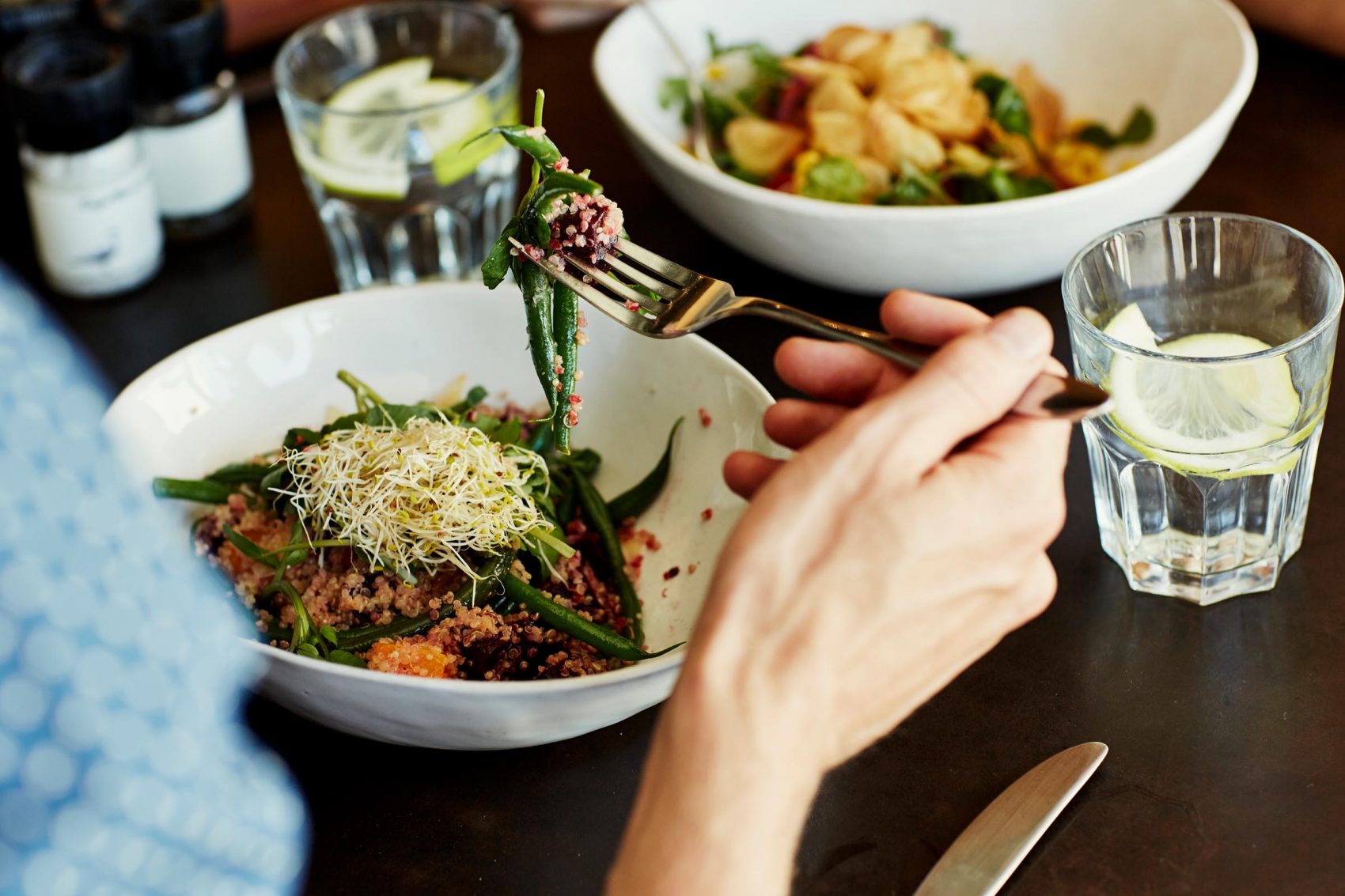 Person eating a bean sprout, vegetable and quinoa salad