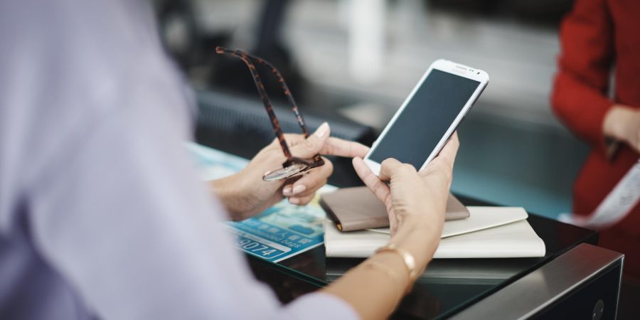 A person holding a phone at the airport check in counter