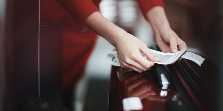 A ground crew attaching a tag onto a luggage.