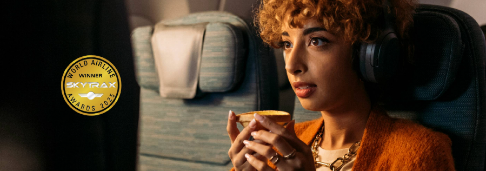A woman watching movie in a cabin with egg tart in hand