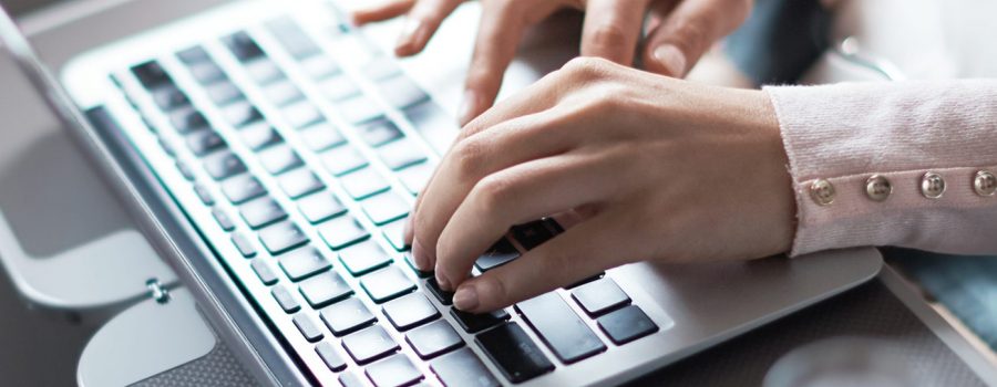 Hands typing on a laptop 