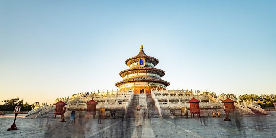 Front view of the Temple of Heaven in Beijing. In the front are blurred human silhouettes at site's entrance grounds.